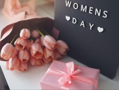 Women's Day sign with pink tulips and present